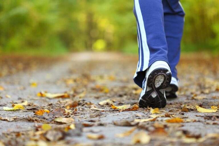 Walking shoes on a leaf-covered path